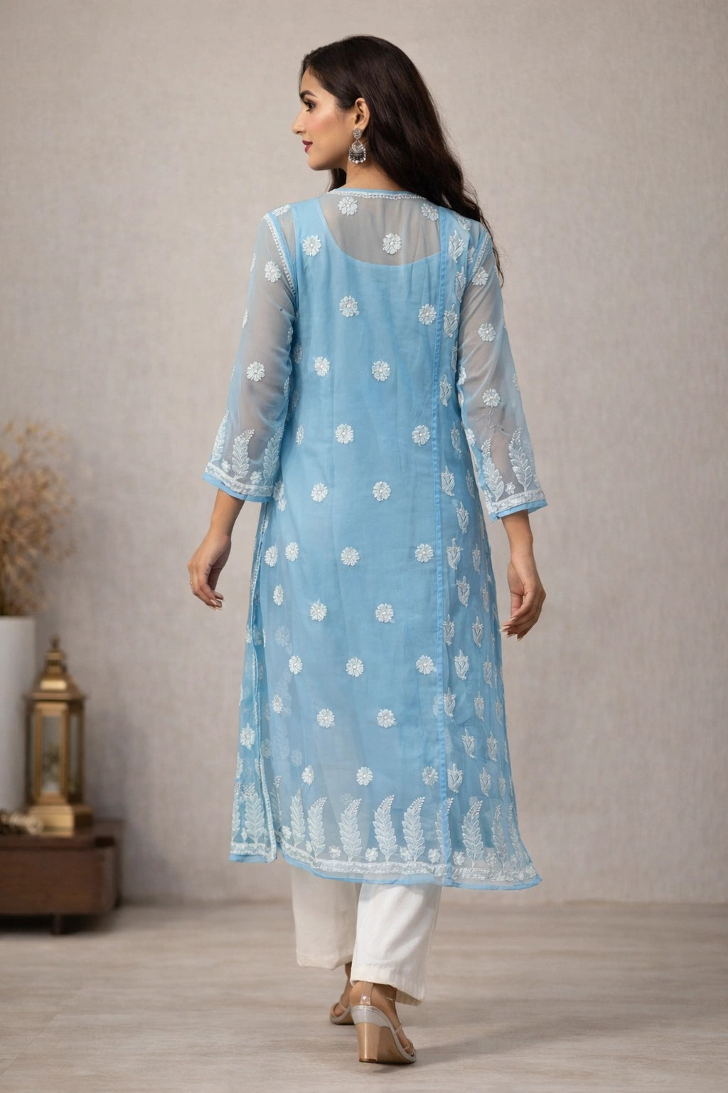 Woman wearing a light blue kurta with white polka dots and white pants, standing against a neutral background.