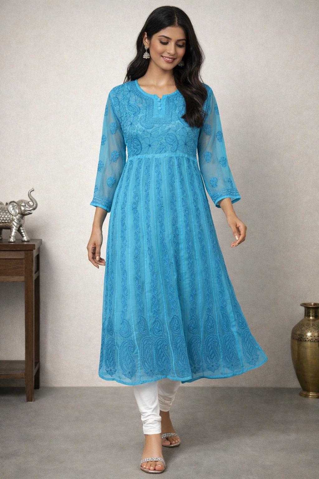 Woman wearing a blue lucknowi chikankari anarkali sitting on a chair.