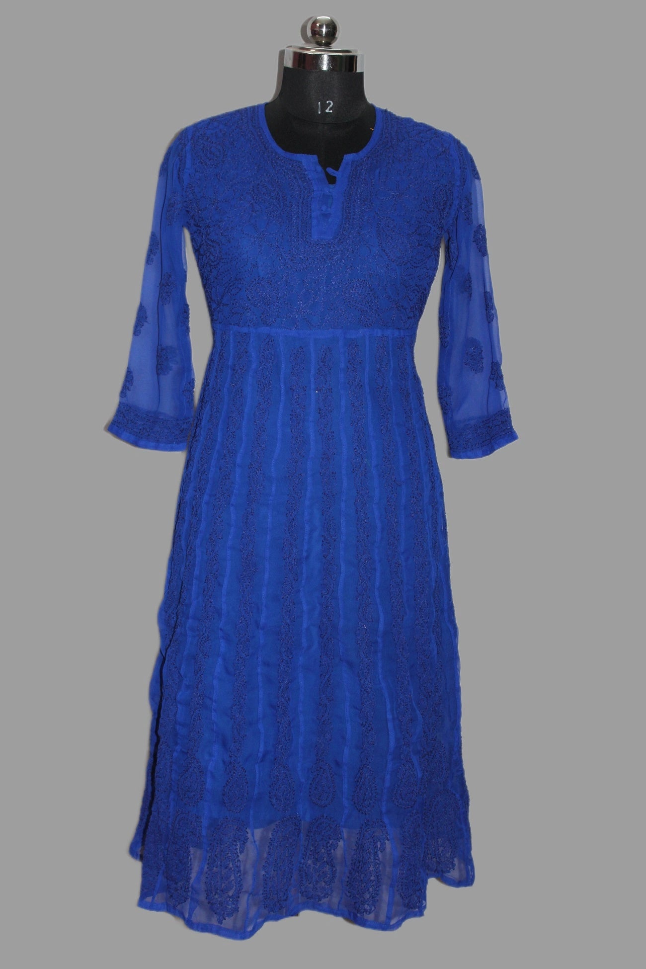 Blue hand embroidered anarkali kurta on a mannequin against a wooden background