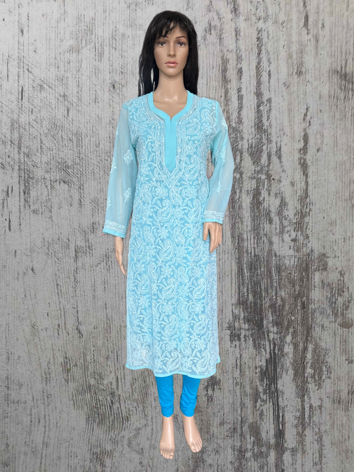 A blue embroidered kurta displayed on a female mannequin, paired with blue leggings wooden background.