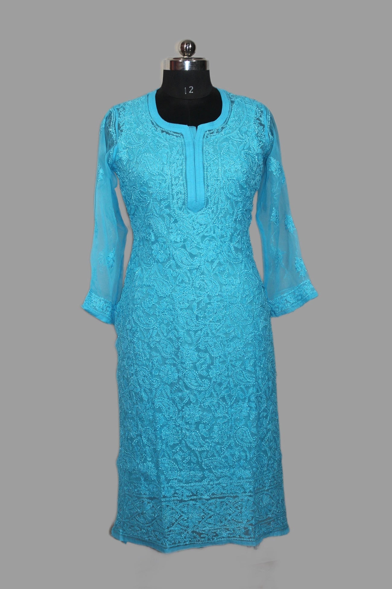 Blue lace dress on a mannequin against a gray background