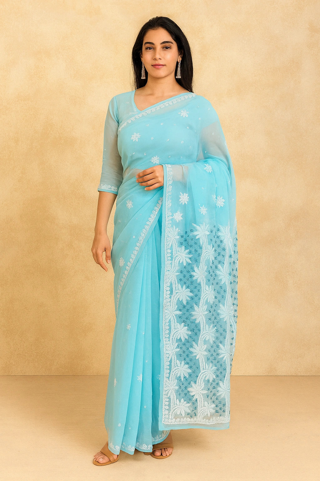 Woman wearing a lucknowi chikankari  light blue saree with white patterns against a beige background