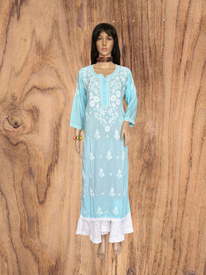 A light blue three-quarter sleeve kurta with white floral embroidery and a white lace hem, displayed on a female mannequin against a brown wood grain background.