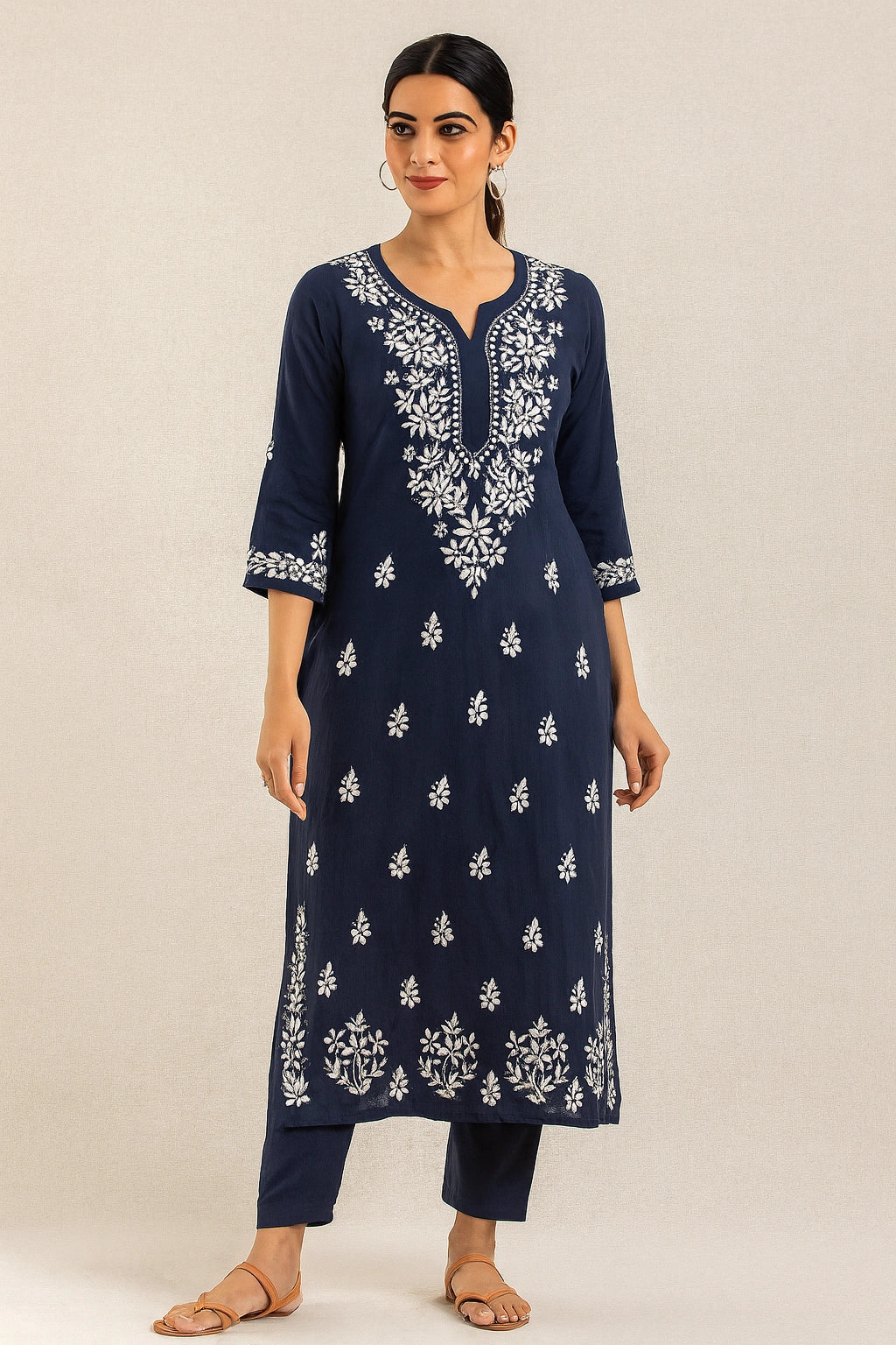 Woman wearing a navy blue kurta with white embroidery on a beige background