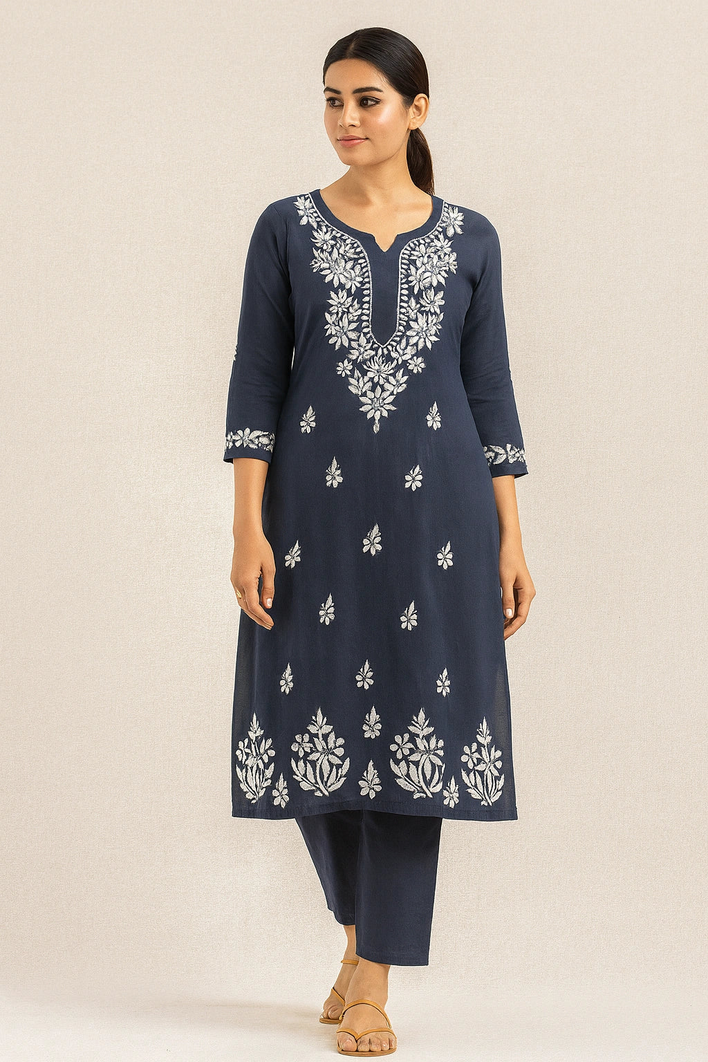 Woman wearing a navy blue embroidered kurta with white patterns on a beige background