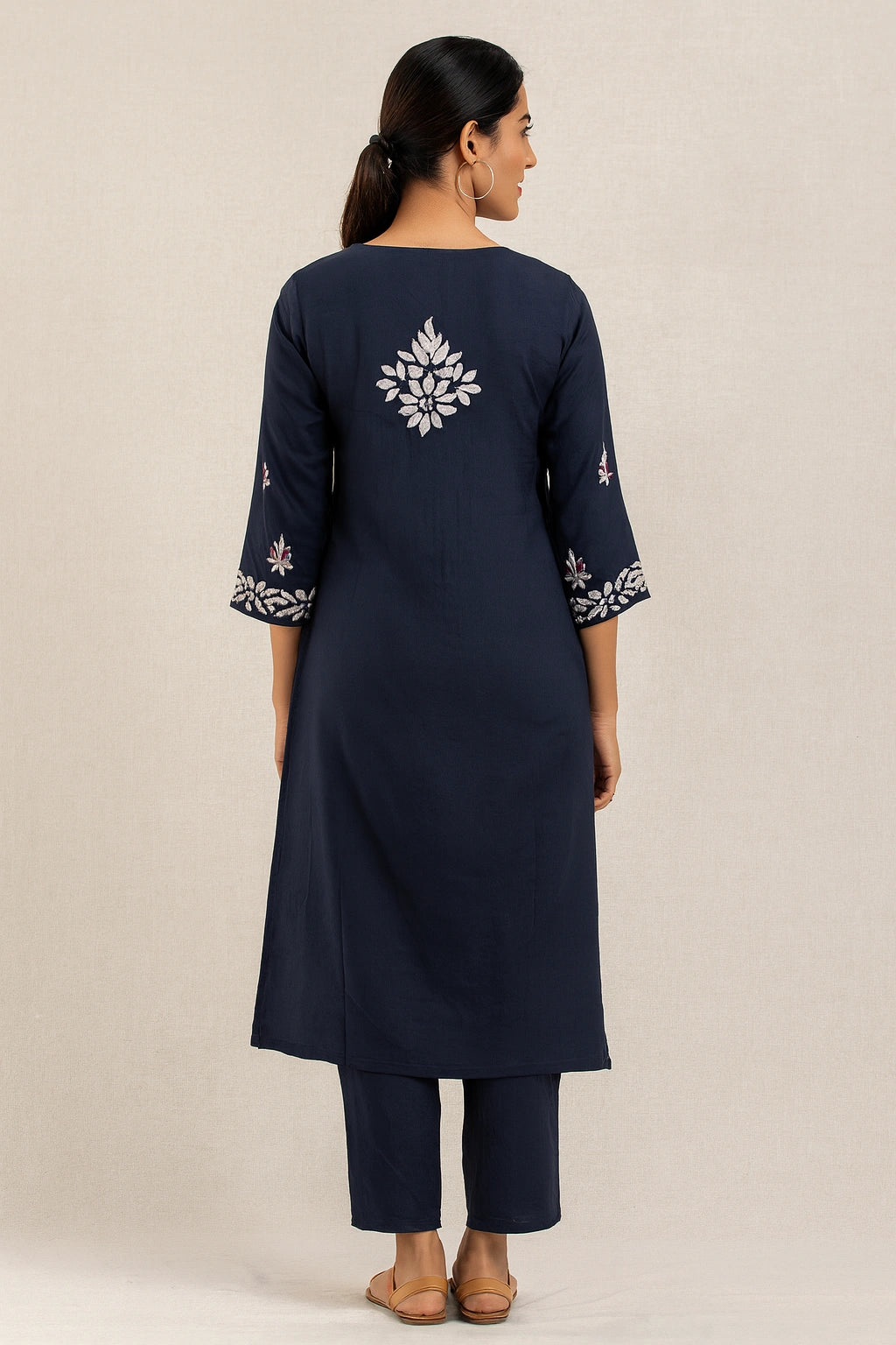 Navy blue kurta with white floral embroidery on a beige background