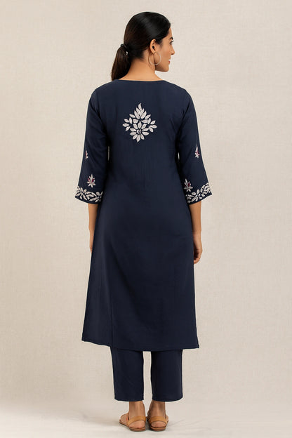 Navy blue kurta with white floral embroidery on a beige background