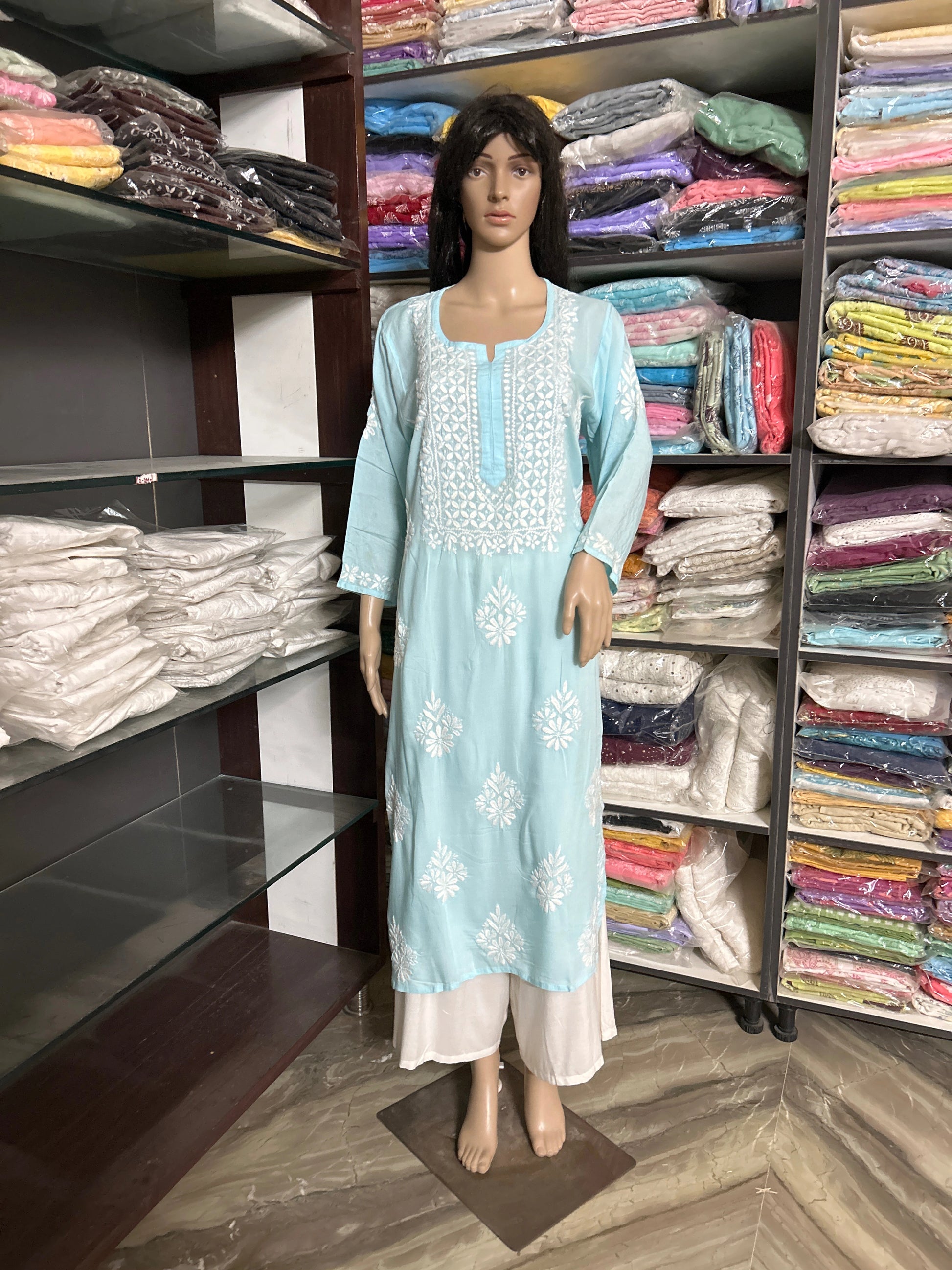 Blue kurta with white floral embroidery on a beige background