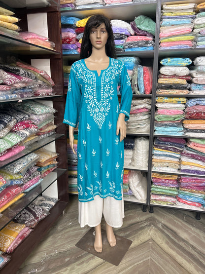 Mannequin wearing a blue embroidered dress in a fabric store