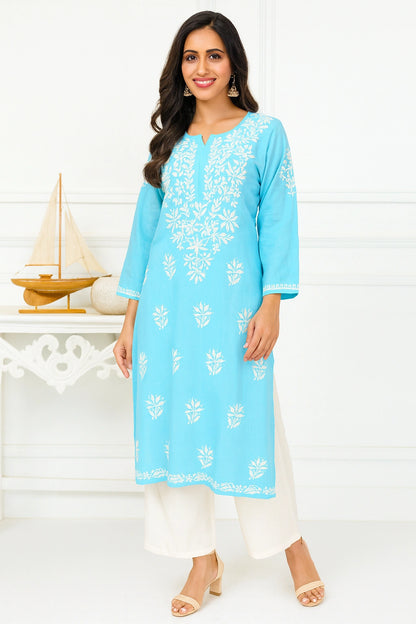 Woman wearing a light blue embroidered kurta with white pants on a white background