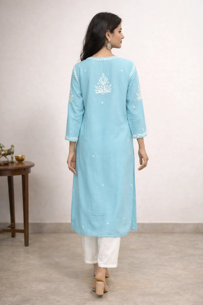 Woman wearing a light blue kurta with white embroidery on a plain background