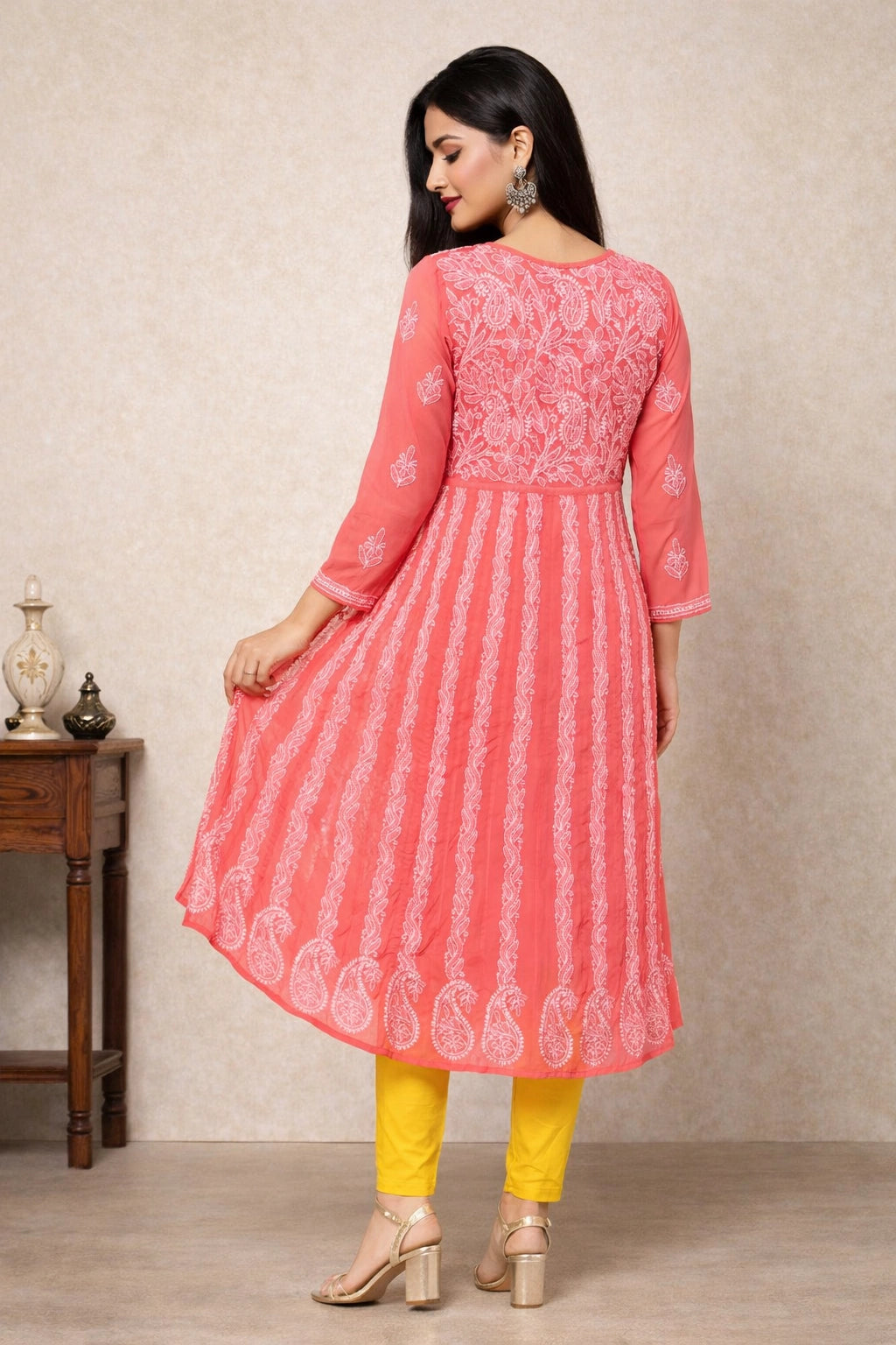 Woman wearing a pink traditional outfit with white patterns on a neutral background