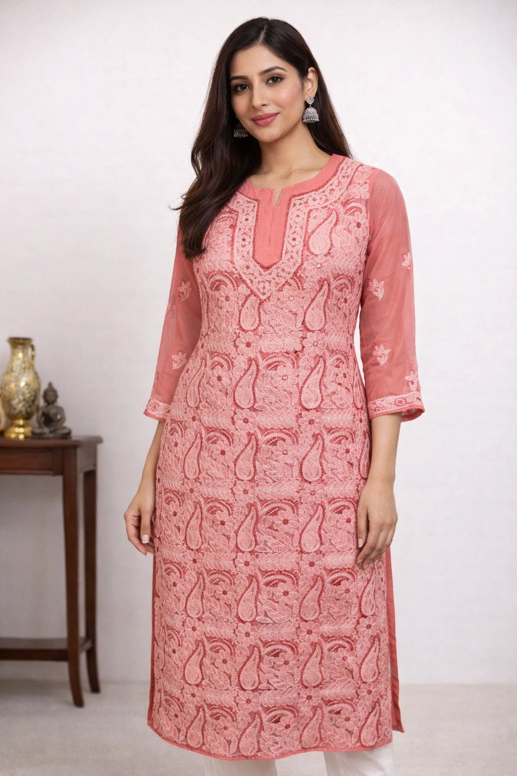 Woman wearing a pink patterned kurta with a white background