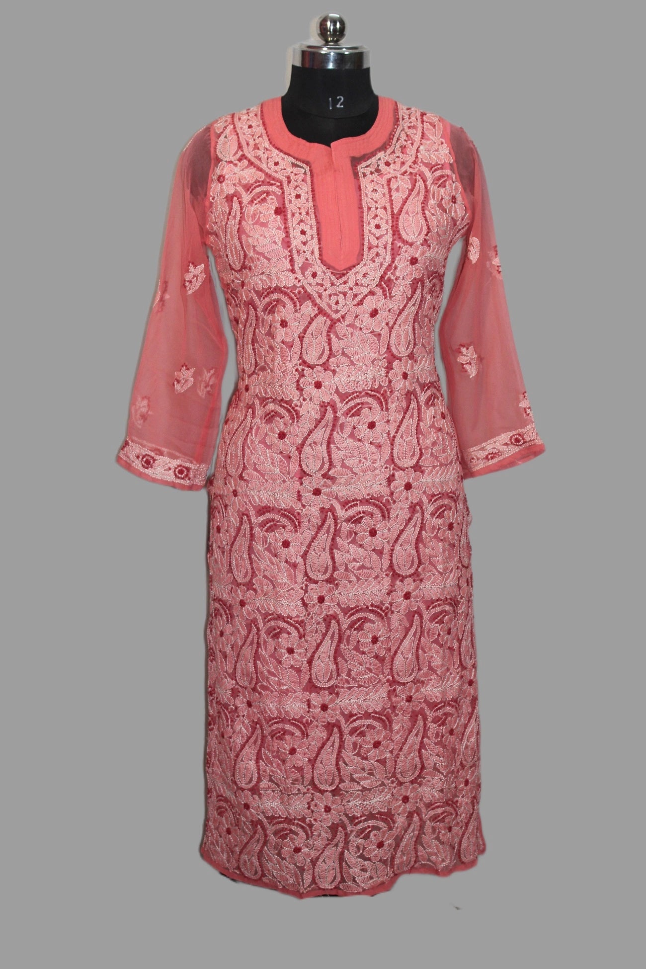 Pink and white patterned dress on a mannequin against a gray background