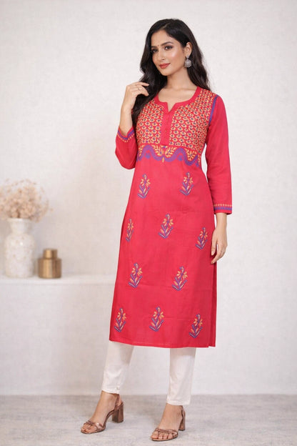 Woman wearing a red embroidered kurta with white pants against a white background