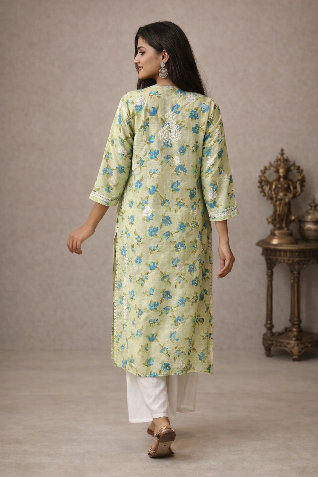 Woman wearing a lucknowi light blue kurta with white pants in a minimalistic setting.