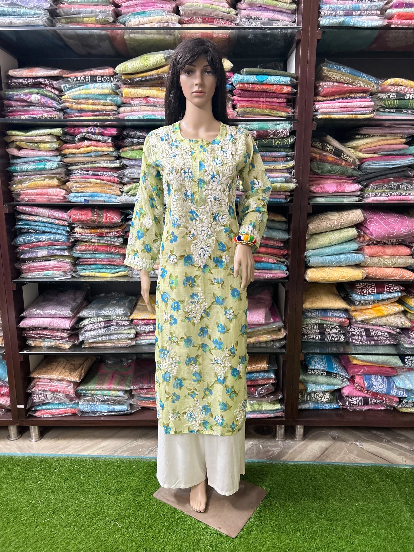 Mannequin wearing a cream-colored embroidered dress on a gray background