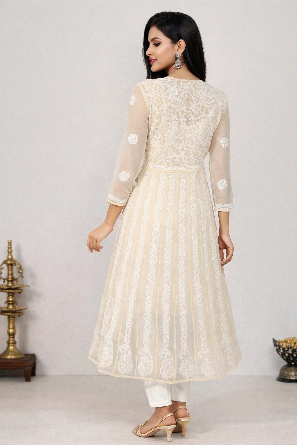 Woman wearing a lucknowi light blue kurta with white pants in a minimalistic setting.
