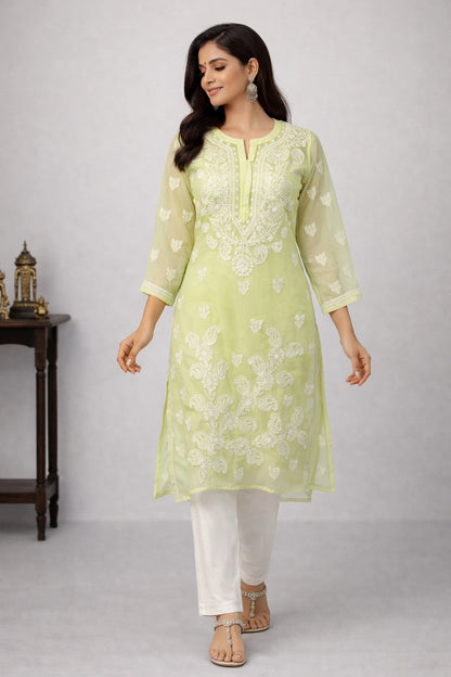 Woman wearing a light green embroidered kurta with white pants on a gray background