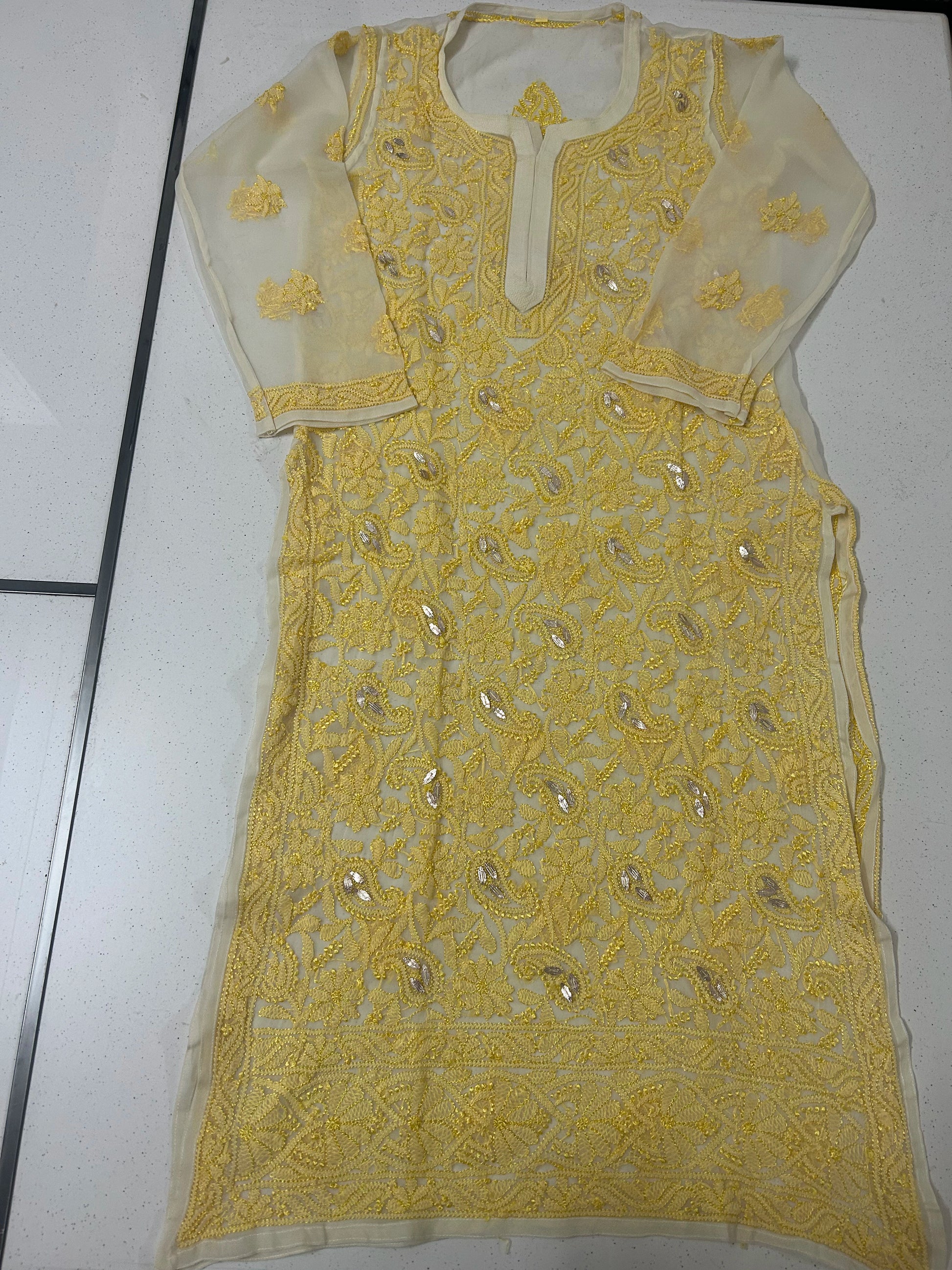 Yellow embroidered dress on a white background