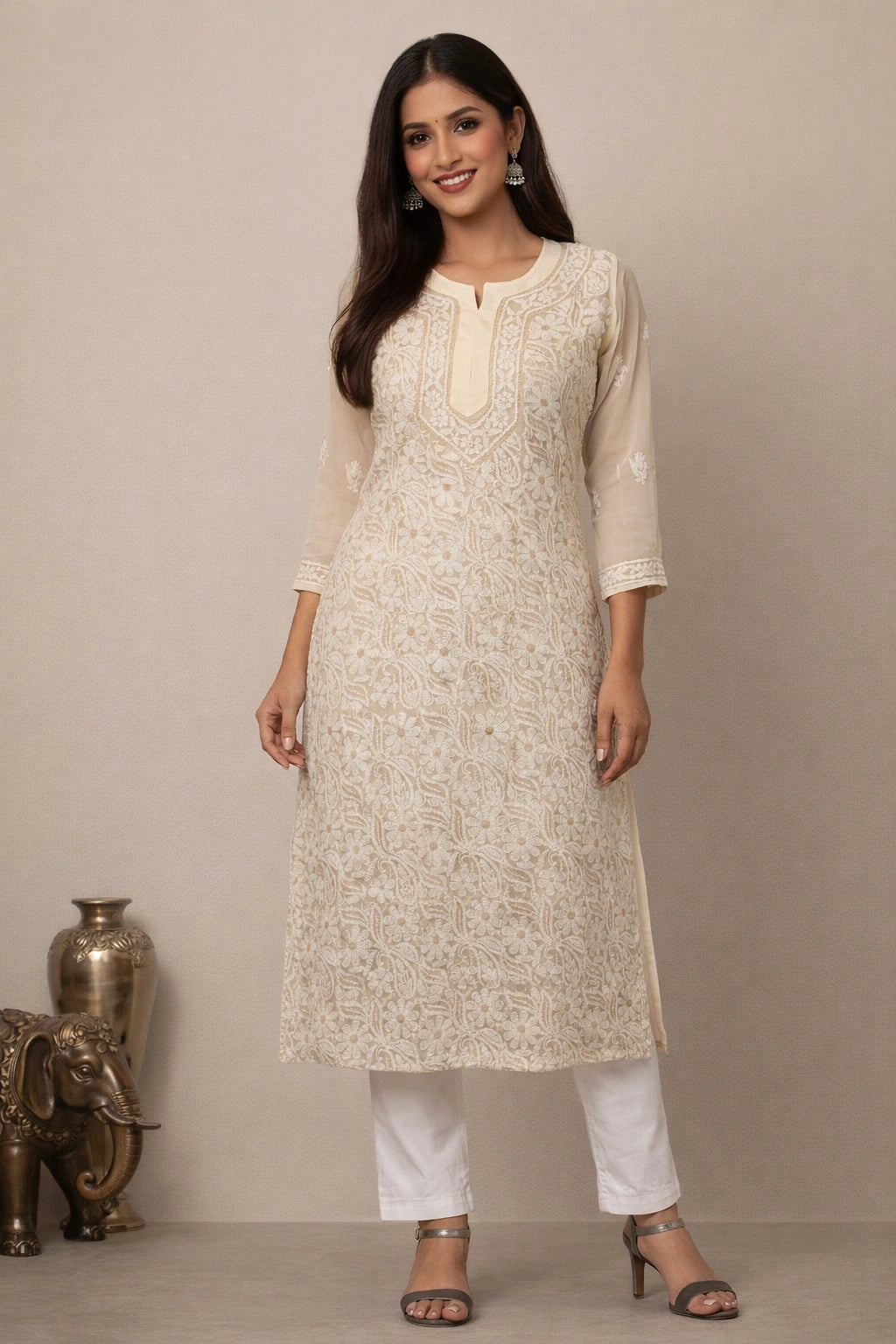 Woman wearing a cream kurta with white pants against a beige background