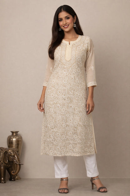 Woman wearing a cream kurta with white pants against a beige background
