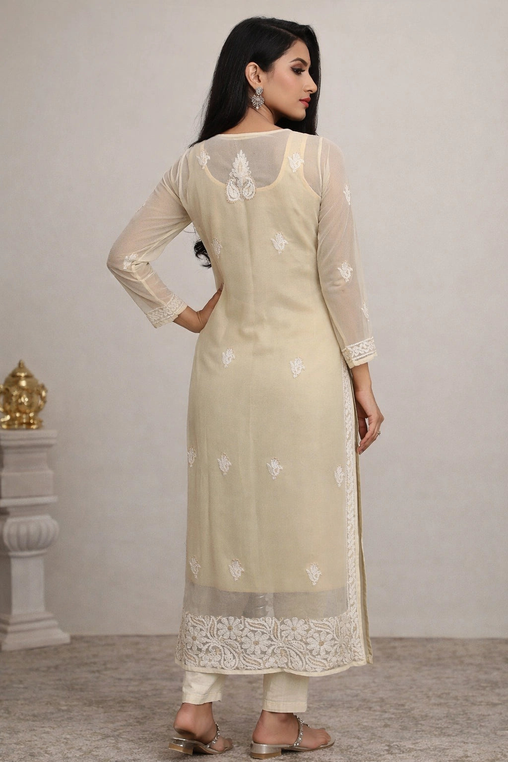 Woman wearing a beige kurta with white floral patterns against a plain background
