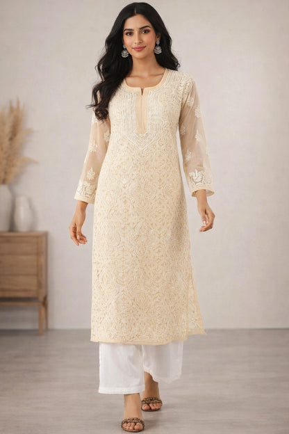 Woman wearing a beige embroidered kurta with white pants in a minimalistic setting.