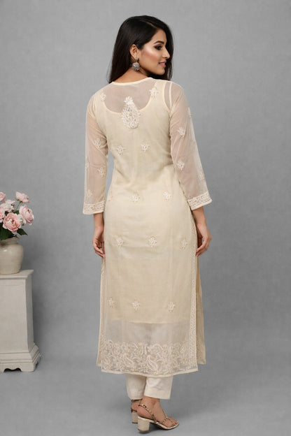 Woman wearing a beige embroidered kurta with a gray background