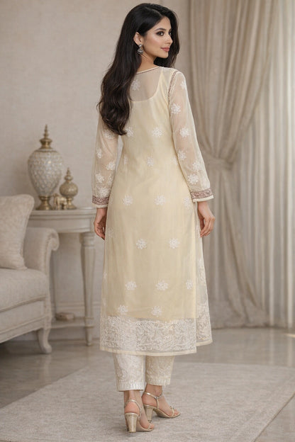Woman wearing a beige lucknowi chikankari traditional outfit in a stylish room.