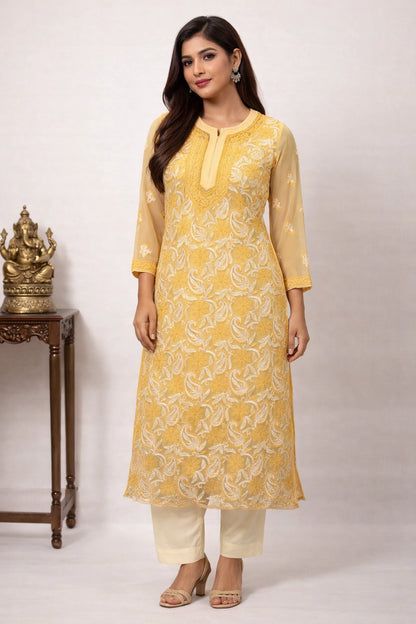 Woman wearing a yellow kurta with white patterns on a plain background
