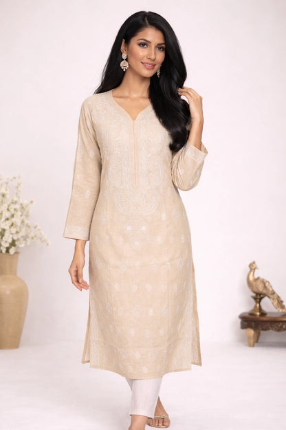 Woman wearing a lucknowi chikankari beige kurta with white pants against a white background