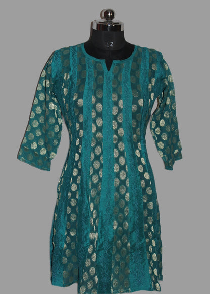 Teal patterned dress on a mannequin against a gray background