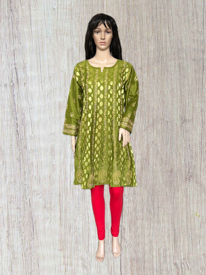 Mannequin wearing a green patterned kurta with red pants on a wooden background