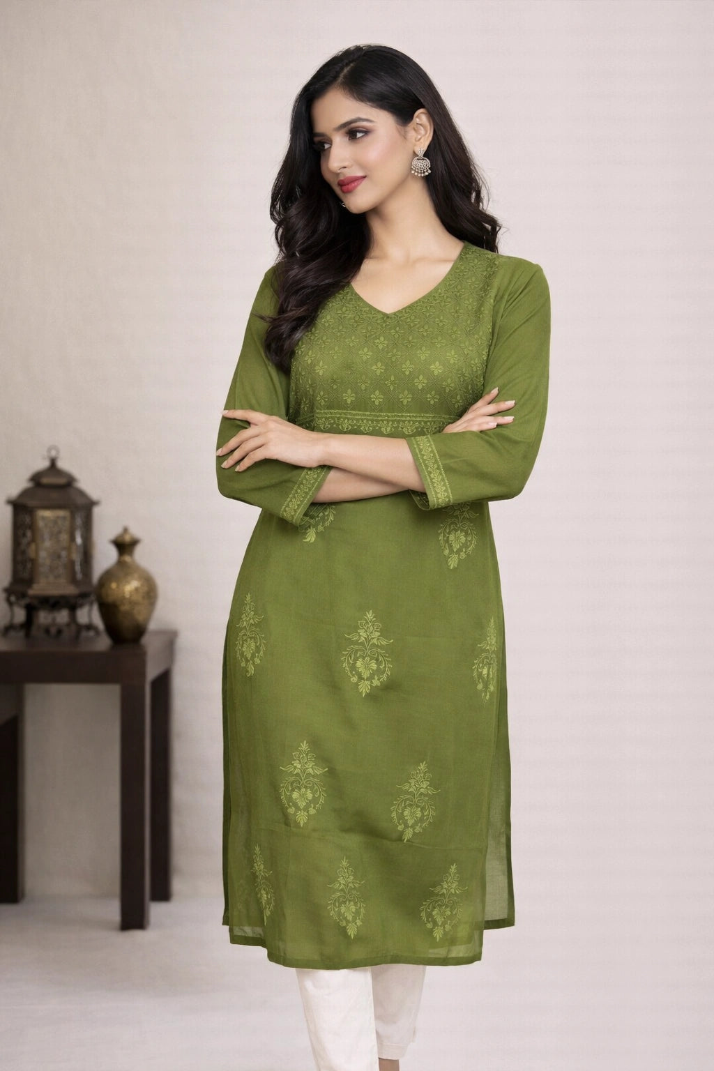 Woman wearing a green kurta with white pants against a neutral background