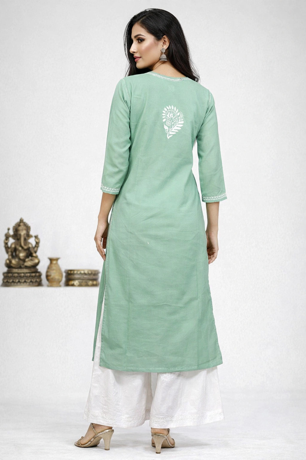 Lucknowi chikankari Woman wearing a light green kurta with white pants on a white background