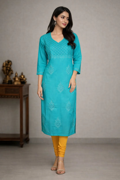 Lucknowi chikankari Woman wearing a turquoise kurta with yellow pants against a neutral background