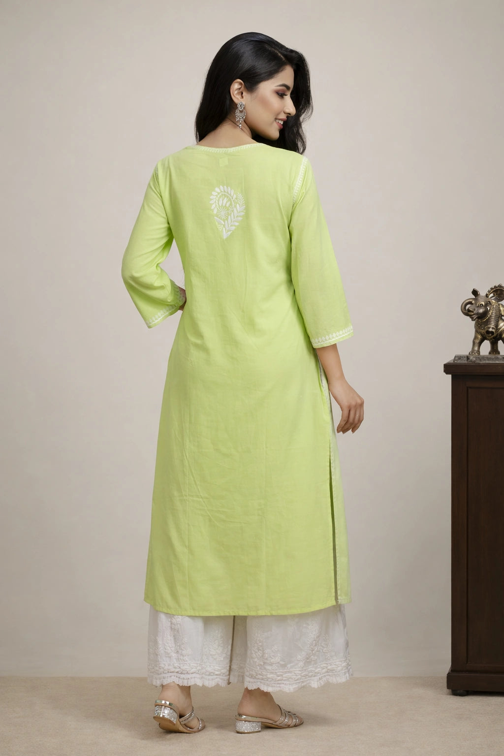 lucknowi chikankari Woman wearing a light green kurta with white pants against a beige background