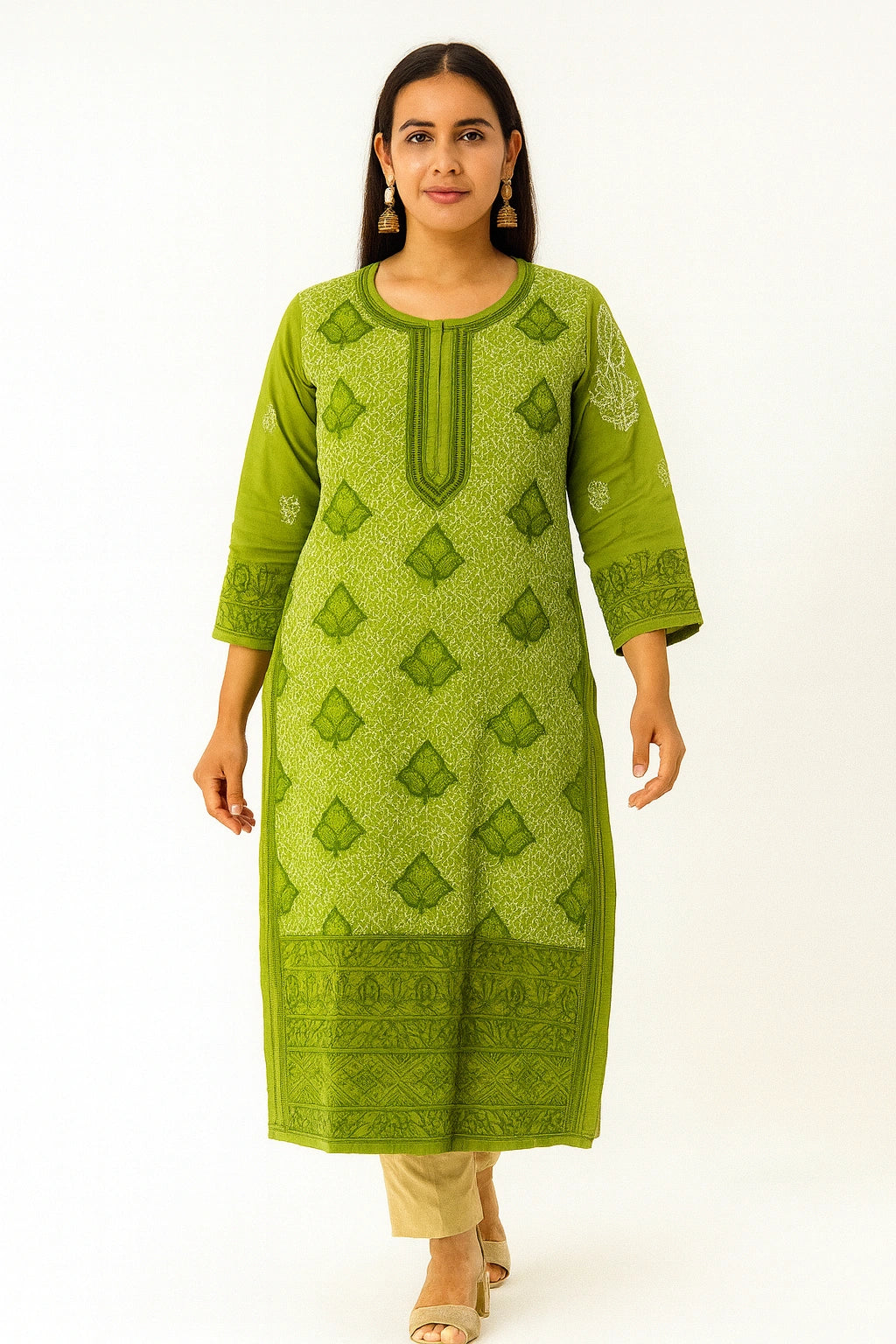 Woman wearing a lucknowi chikankari green patterned kurta with beige pants on a white background