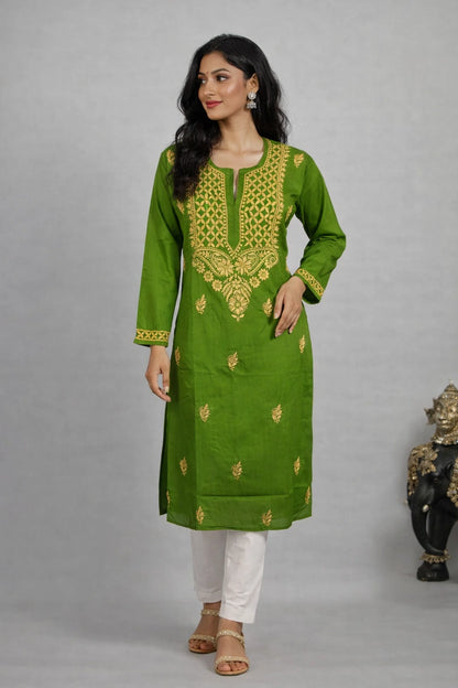 Woman wearing a green embroidered kurta with white pants against a gray background