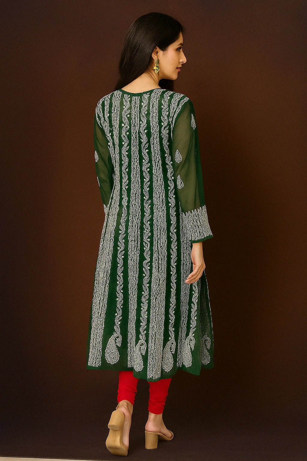 Woman wearing a green embroidered dress against a beige background
