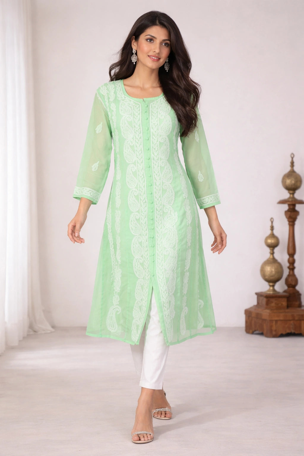Woman wearing a lucknowi chikankari light green kurta with white pants in a minimalistic setting