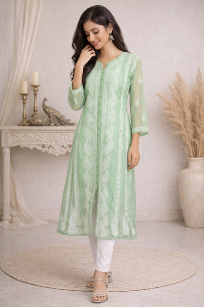 Woman wearing a light green kurta with white pants in an indoor setting.