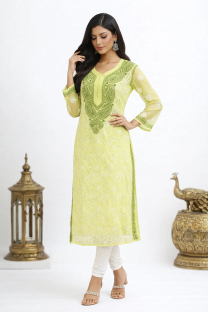 Woman wearing a light green embroidered kurta with white pants against a white background