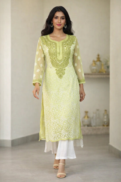 Woman wearing a light green embroidered kurta with white pants in an indoor setting.