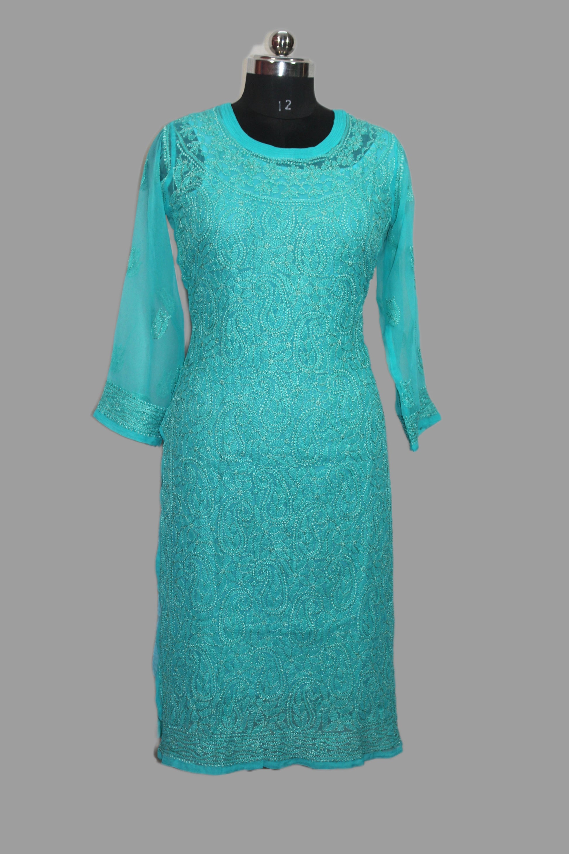 Teal lace dress on a mannequin against a gray background