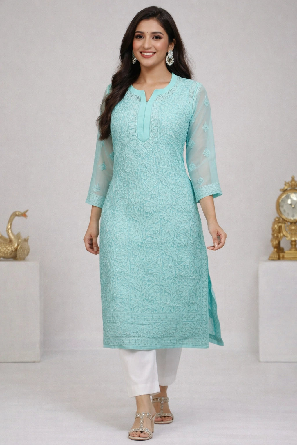 Woman wearing a lucknowi chikankari light blue kurta with white pants on a gray background