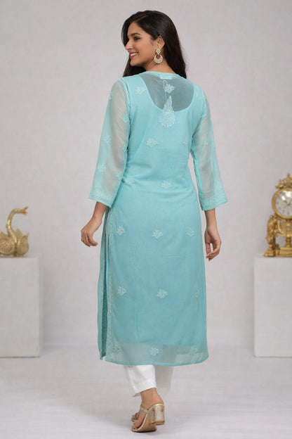 Woman wearing a lucknowi light blue kurta with white pants on a plain background