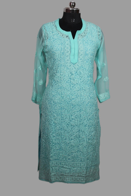 Turquoise embroidered dress on a mannequin against a gray background