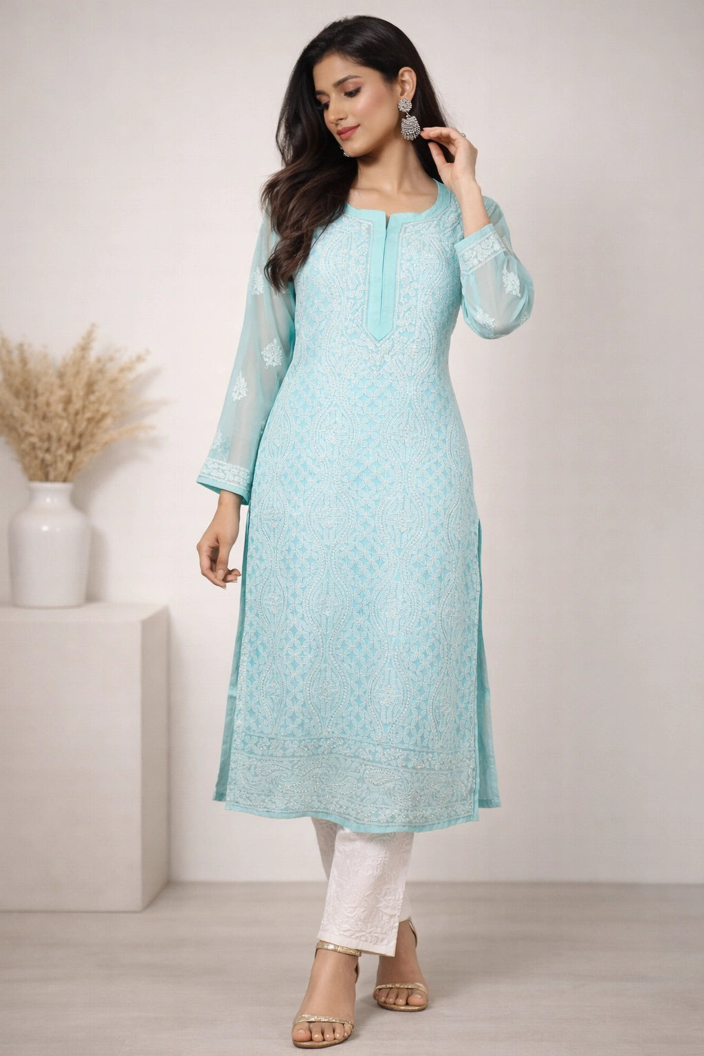Woman wearing a lucknowi chikankari light blue kurta with white pants in a minimalistic setting.